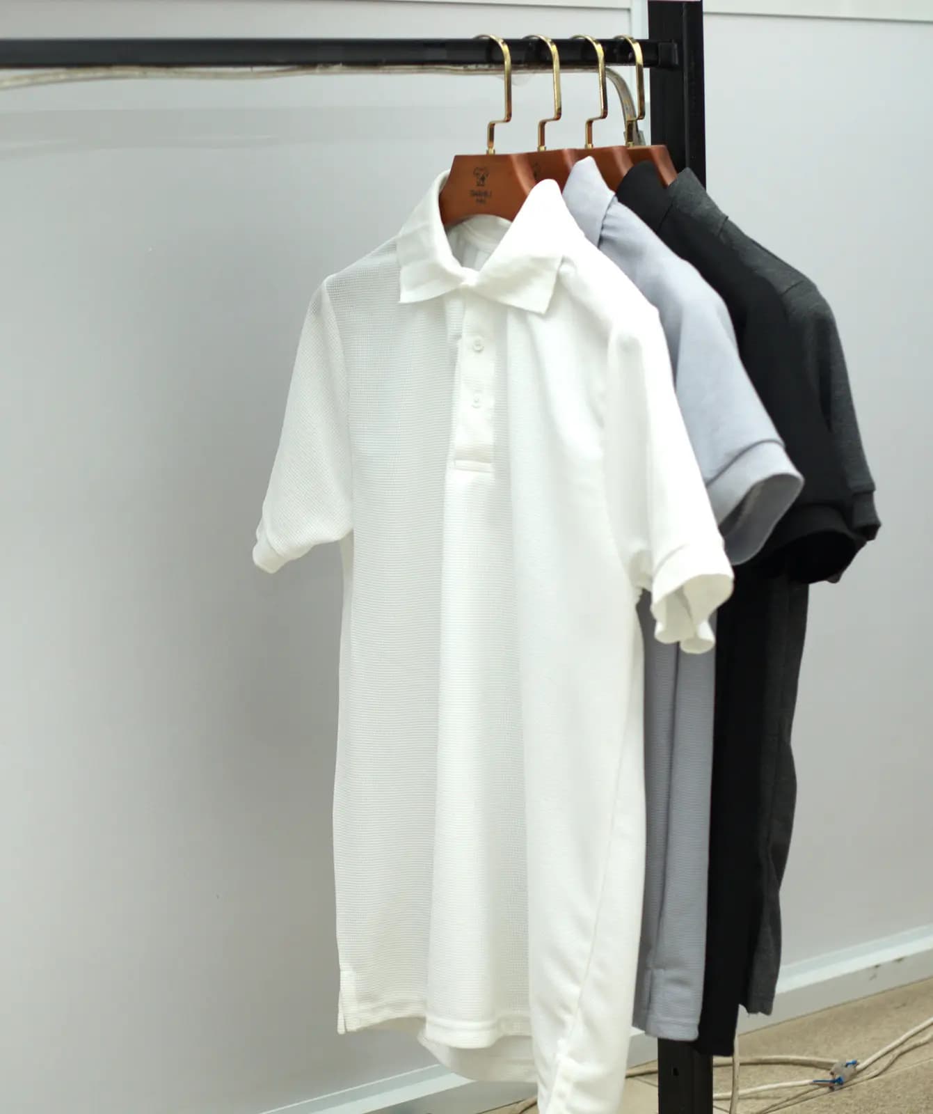 White pique polo shirt on a hanger