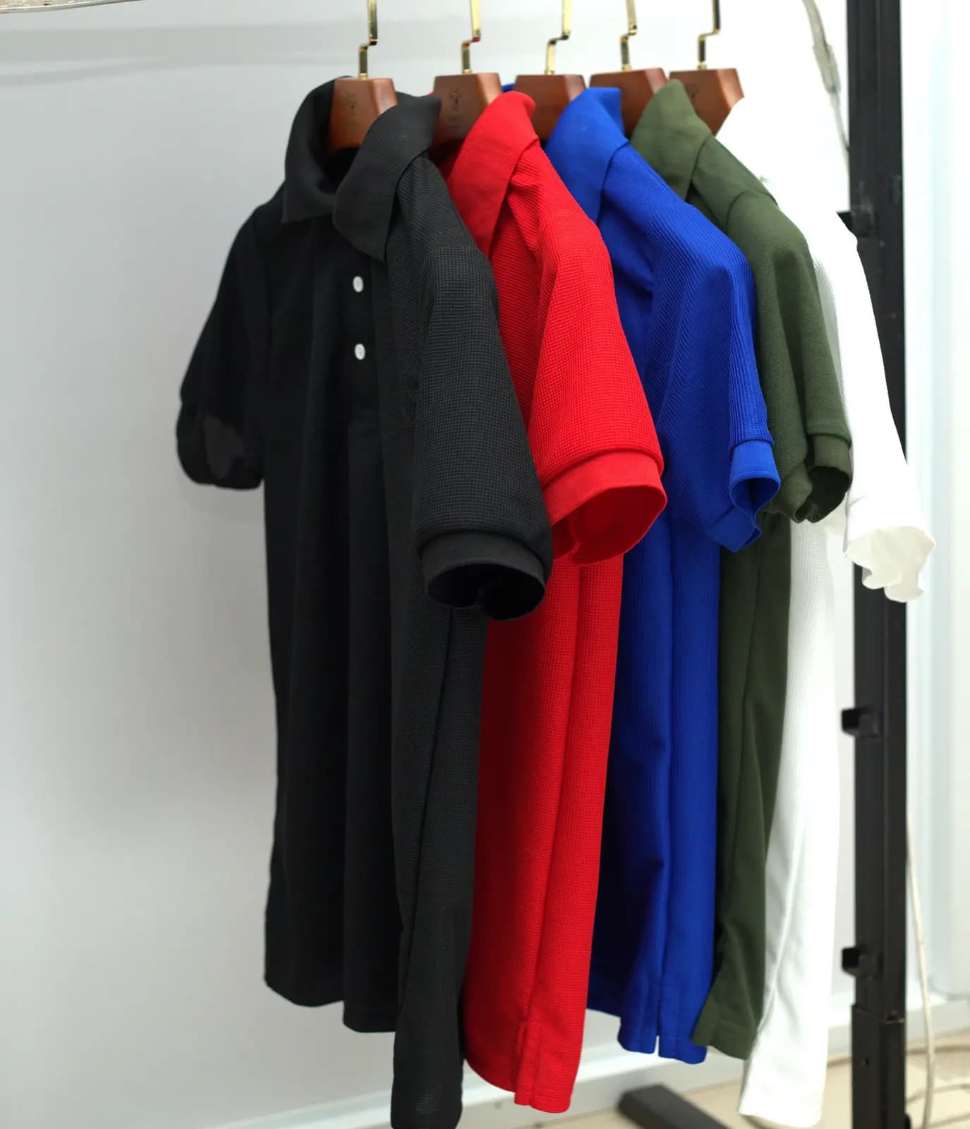Polo shirts in black, red, blue and olive on the rail